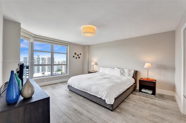 bedroom featuring light wood-type flooring and baseboards