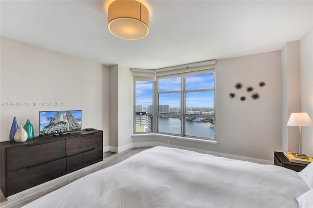 bedroom with light wood-style flooring and baseboards