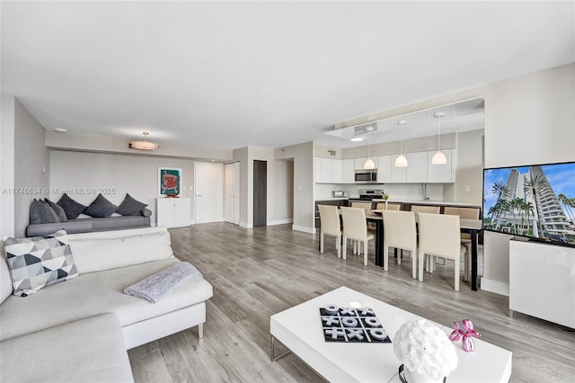living area with light wood-style flooring and baseboards