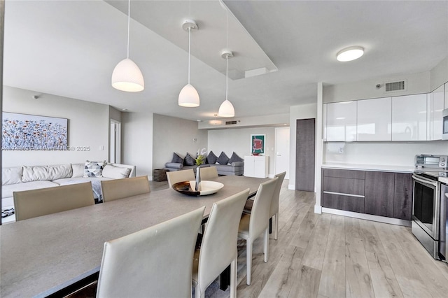 dining room with light wood-style flooring and visible vents