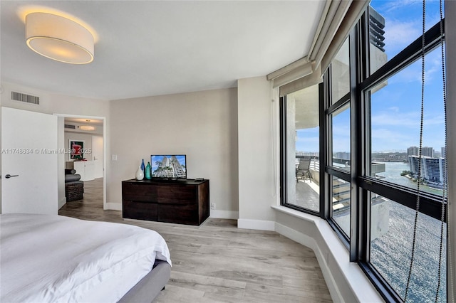 bedroom featuring baseboards, visible vents, and light wood finished floors