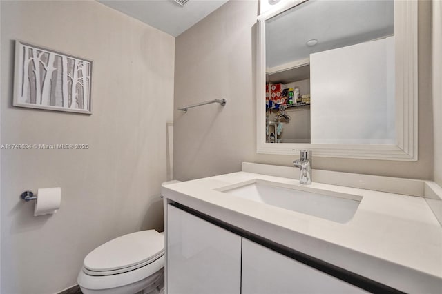 half bathroom featuring vanity and toilet