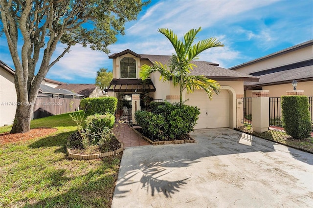 view of front of property featuring concrete driveway, a fenced front yard, an attached garage, a front lawn, and stucco siding