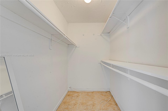 spacious closet with light tile patterned floors