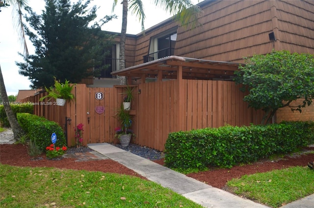 exterior space with mansard roof, fence, and brick siding