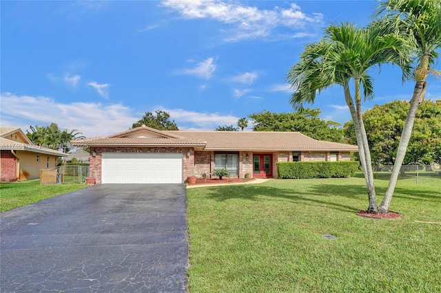 ranch-style home featuring fence, driveway, an attached garage, a front lawn, and a tiled roof