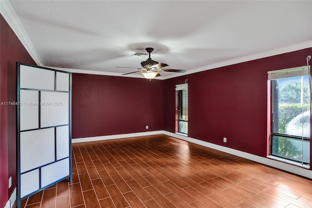 empty room with wood finished floors, baseboards, and ornamental molding