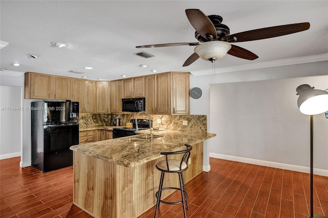 kitchen with wood finish floors, visible vents, black appliances, a peninsula, and decorative backsplash