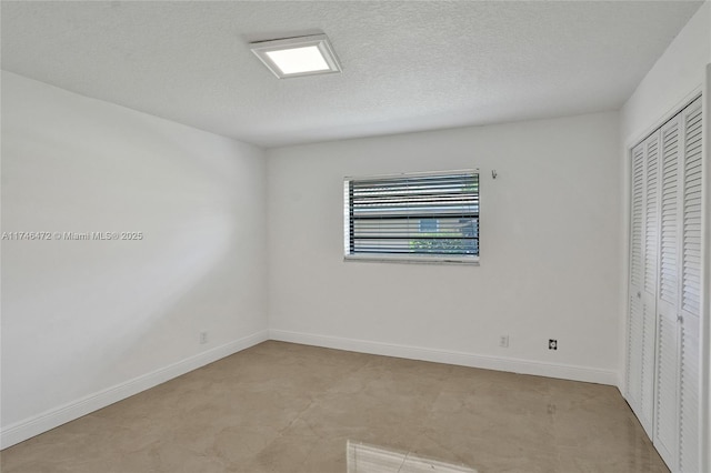 unfurnished bedroom with a closet, baseboards, and a textured ceiling