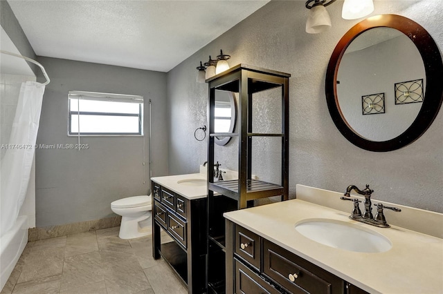 bathroom featuring a textured ceiling, toilet, a textured wall, and a sink