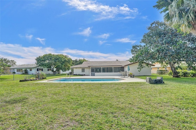 rear view of property featuring fence, a lawn, a sunroom, an outdoor pool, and a patio