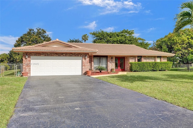 single story home featuring a front yard, fence, driveway, an attached garage, and a tiled roof