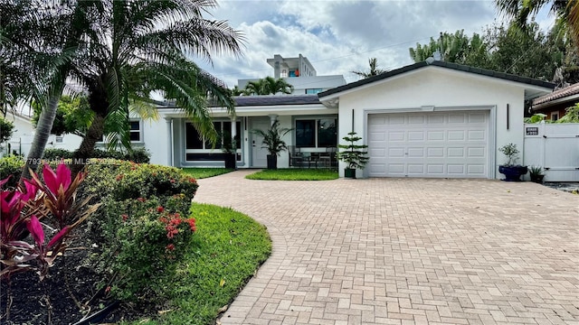 3204 Robbins Rd, Pompano Beach, FL 33062 - ranch-style house with decorative driveway, stucco siding, and a garage