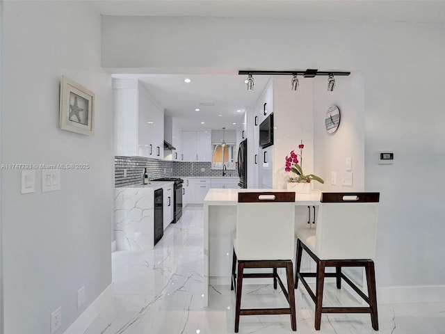 3204 Robbins Rd, Pompano Beach, FL 33062 - kitchen featuring black appliances, a peninsula, white cabinetry, light countertops, and decorative backsplash