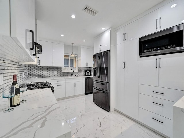 3204 Robbins Rd, Pompano Beach, FL 33062 - kitchen featuring appliances with stainless steel finishes, backsplash, a sink, light stone counters, and white cabinetry