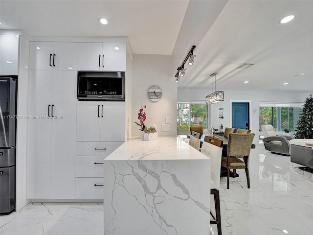 3204 Robbins Rd, Pompano Beach, FL 33062 - kitchen featuring modern cabinets, white cabinets, light marble finish floors, light stone counters, and a kitchen bar