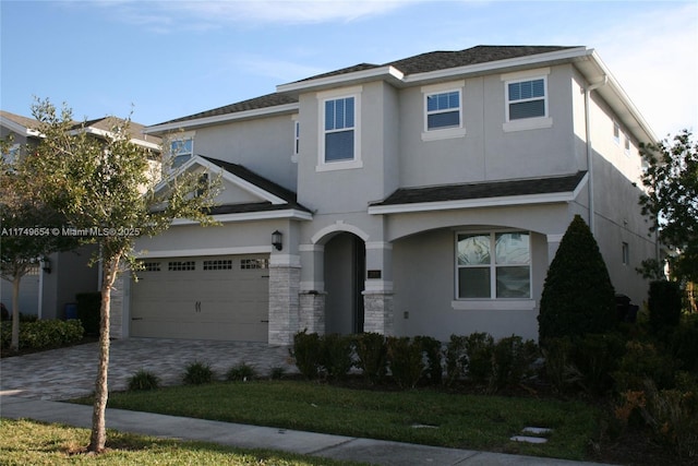 view of front facade with decorative driveway and stucco siding