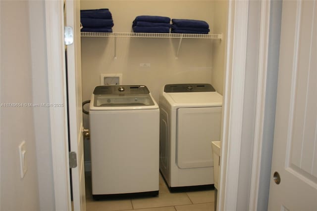 washroom with washer and dryer, laundry area, and light tile patterned floors