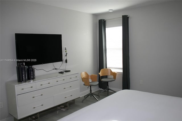 bedroom featuring multiple windows and baseboards