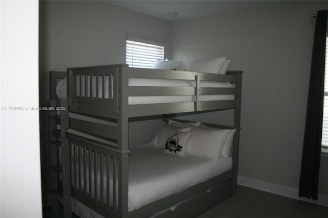 bedroom with baseboards and dark wood finished floors