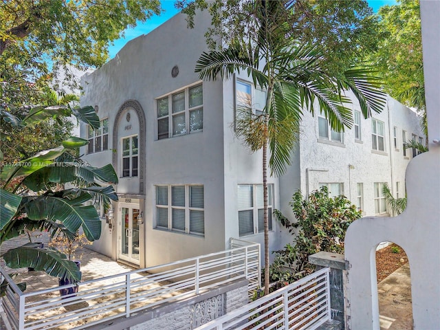 view of side of home featuring french doors and stucco siding