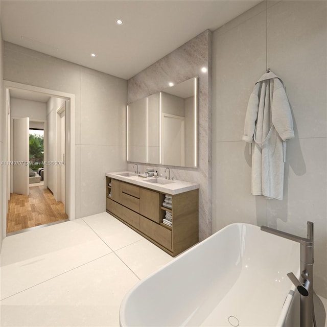 full bathroom with recessed lighting, a sink, tile walls, a freestanding bath, and double vanity