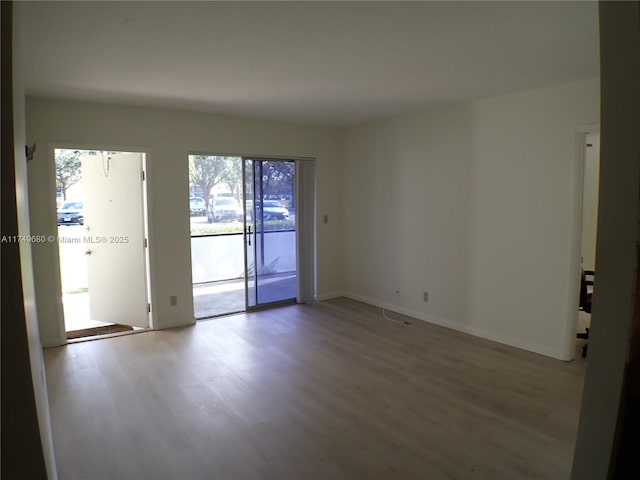 empty room with light wood-type flooring and baseboards