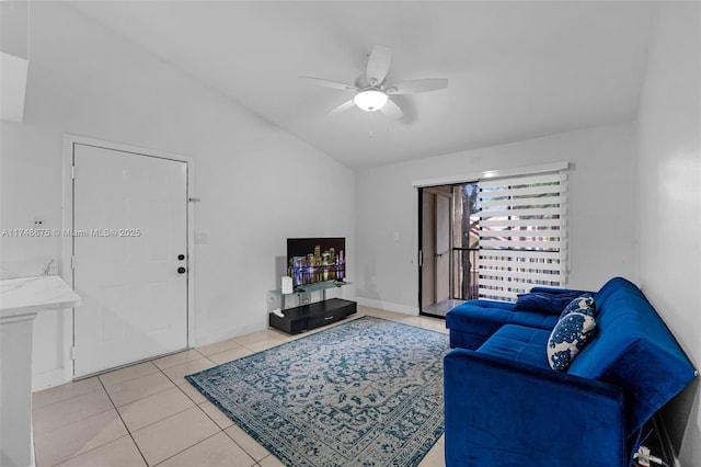 living area featuring light tile patterned floors, ceiling fan, baseboards, and vaulted ceiling