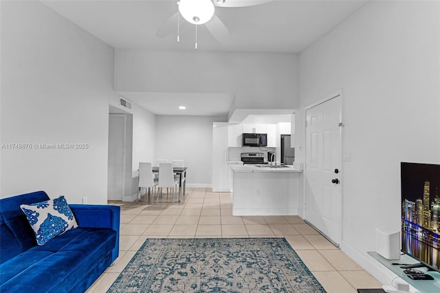 living room with a ceiling fan, visible vents, baseboards, and light tile patterned floors