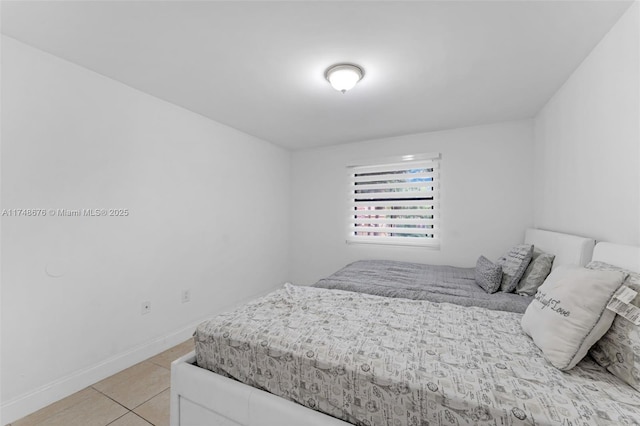 bedroom with light tile patterned floors and baseboards