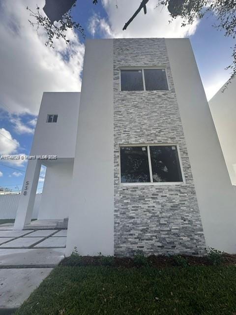 view of home's exterior with stone siding and stucco siding