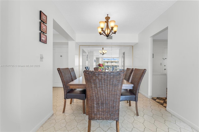 dining space with a chandelier, a textured ceiling, visible vents, and baseboards