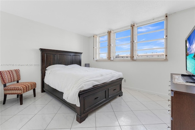 bedroom featuring light tile patterned floors and baseboards