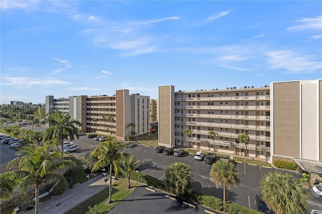 view of building exterior with uncovered parking and a city view