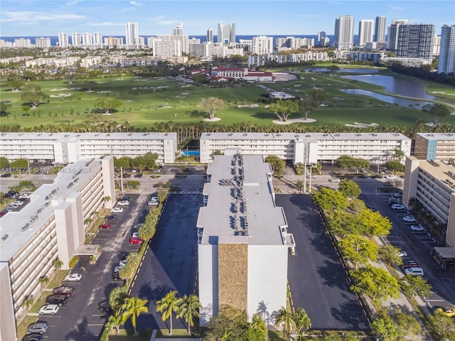 aerial view with view of golf course, a city view, and a water view