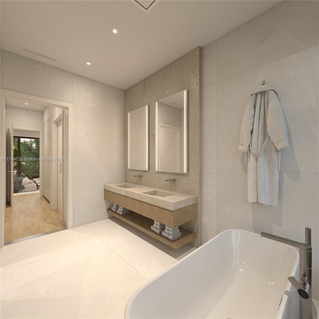 full bathroom with recessed lighting, a soaking tub, tile walls, and double vanity