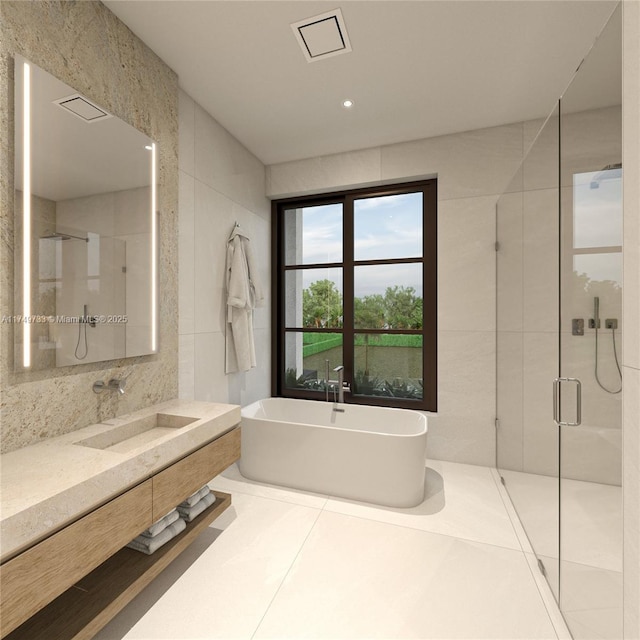 full bathroom with a freestanding tub, vanity, tile walls, a shower stall, and tile patterned floors