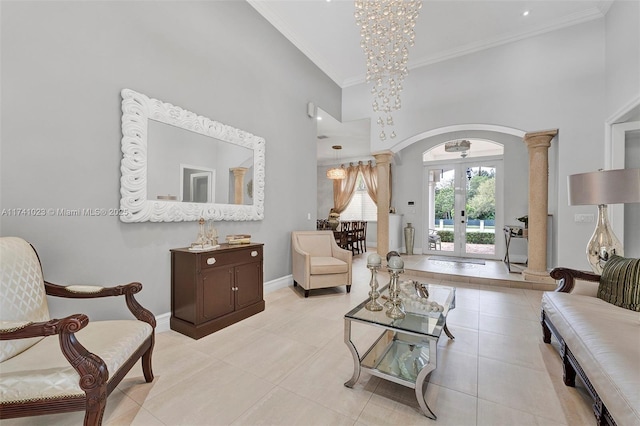 sitting room featuring baseboards, arched walkways, ornamental molding, a high ceiling, and french doors