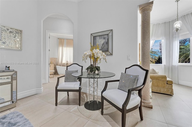 sitting room with arched walkways, light tile patterned flooring, and baseboards