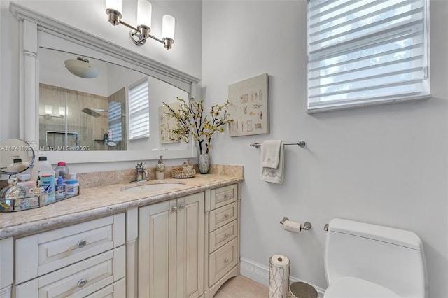 bathroom featuring baseboards, a tile shower, vanity, and toilet