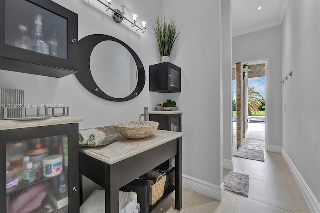 entryway with ornamental molding, baseboards, and light tile patterned floors