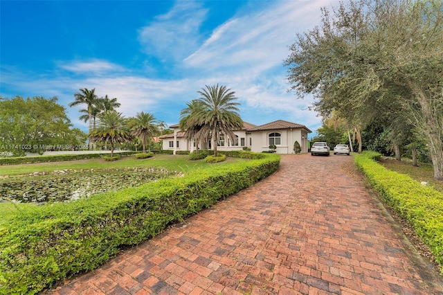 view of front of home featuring a front yard, decorative driveway, and stucco siding