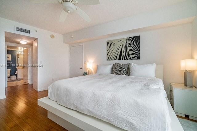 bedroom with visible vents, ceiling fan, baseboards, and wood finished floors