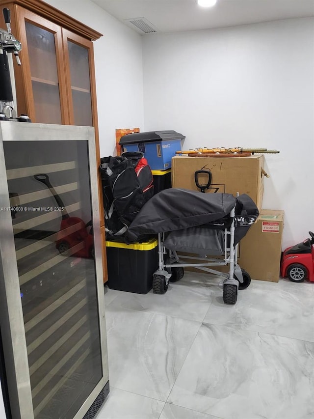 bedroom with beverage cooler, visible vents, and concrete floors