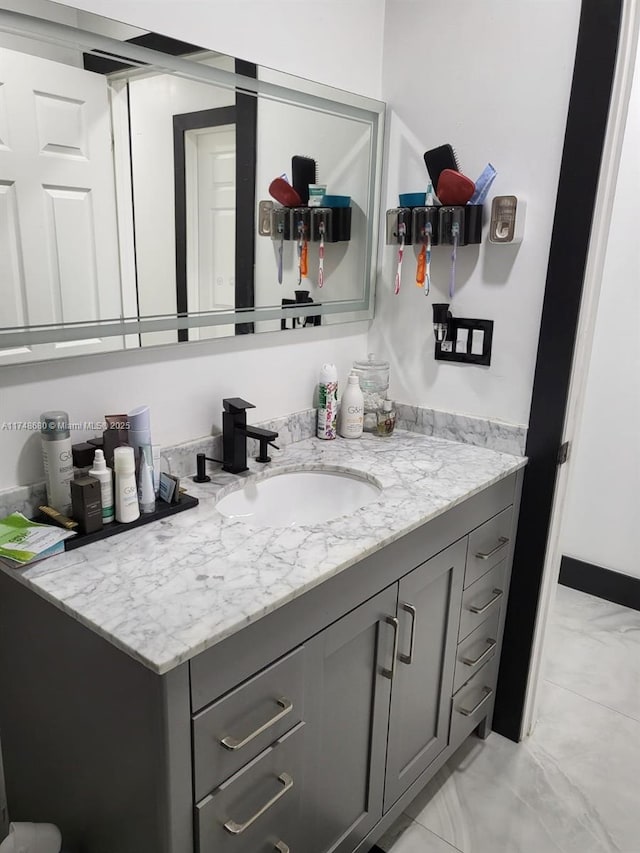 bathroom featuring marble finish floor and vanity