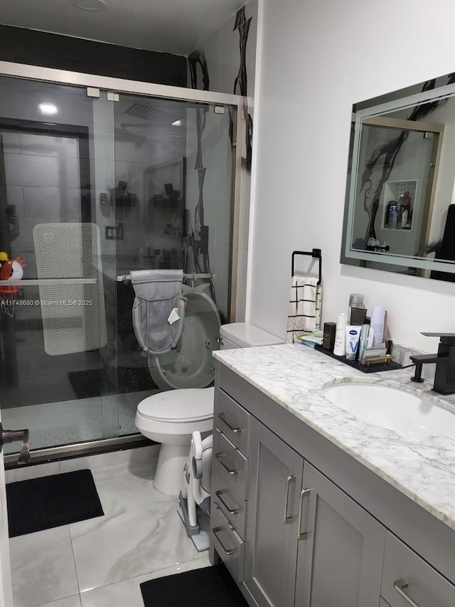 bathroom featuring toilet, a shower stall, and vanity