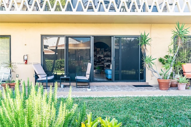 property entrance with a patio area and stucco siding