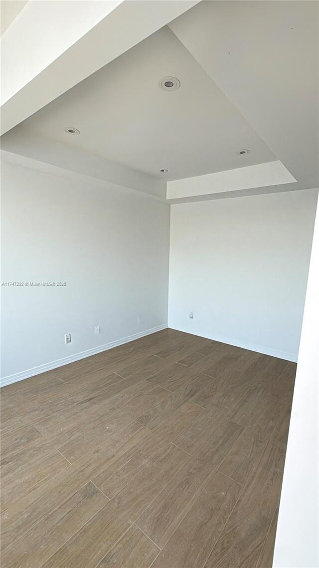 unfurnished room with wood finished floors and baseboards