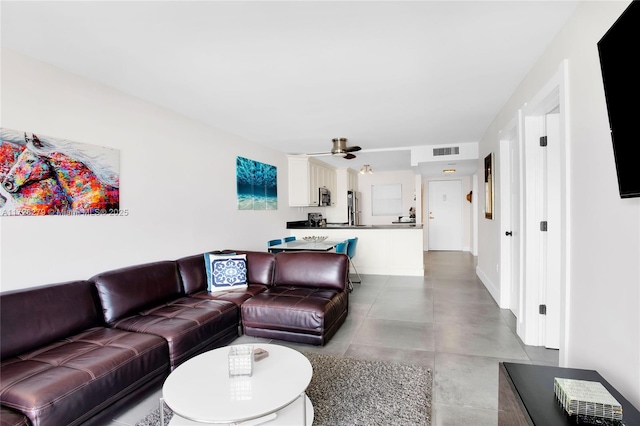 living area featuring a ceiling fan and visible vents