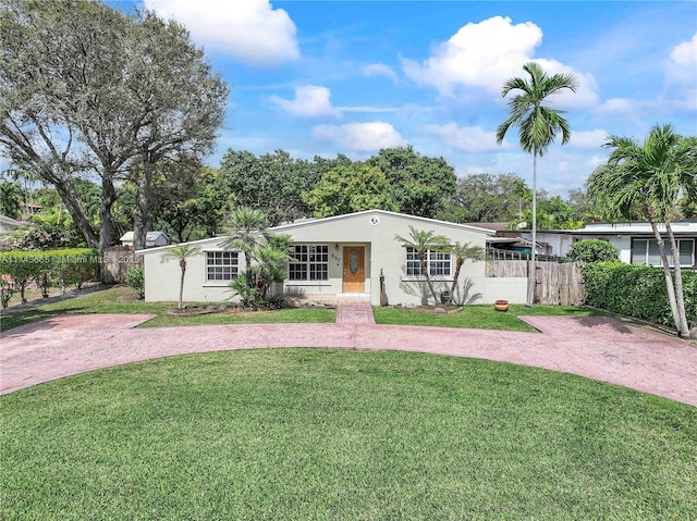 ranch-style house with fence, a front lawn, decorative driveway, and stucco siding